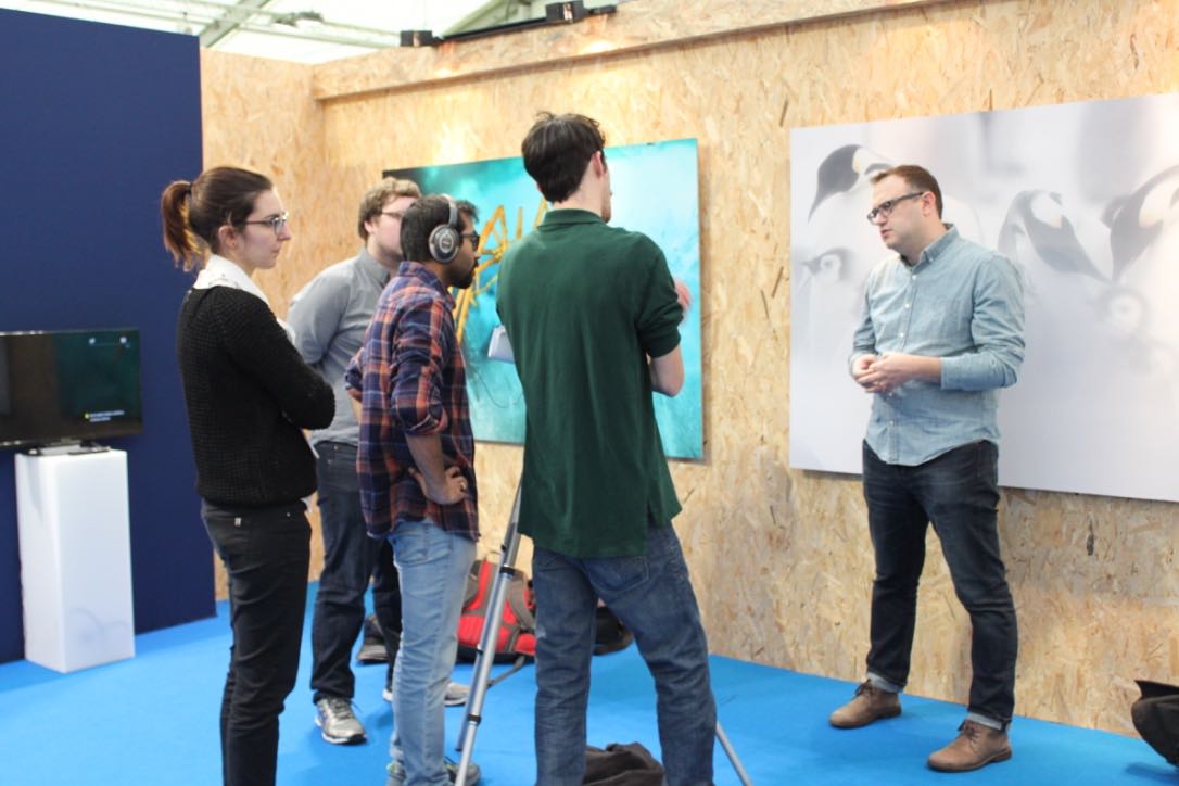 Picture of students listening to a presenter infront of a image gallery